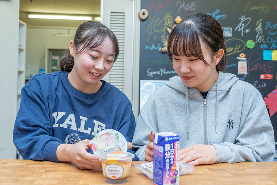 コンビニから研究室に戻り、成分表をチェック。「カロリーと脂質だけは必ずみます」という二人。【写真：増田美咲】 
